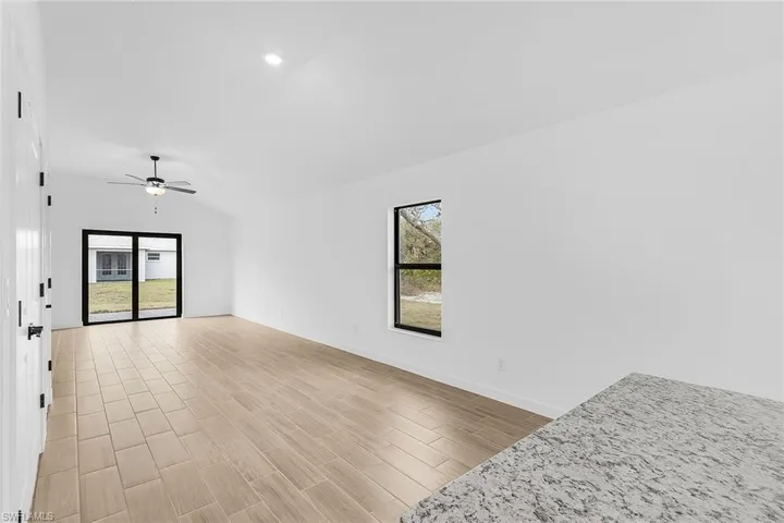 Unfurnished living room with lofted ceiling, ceiling fan, light wood-style floors, and recessed lighting