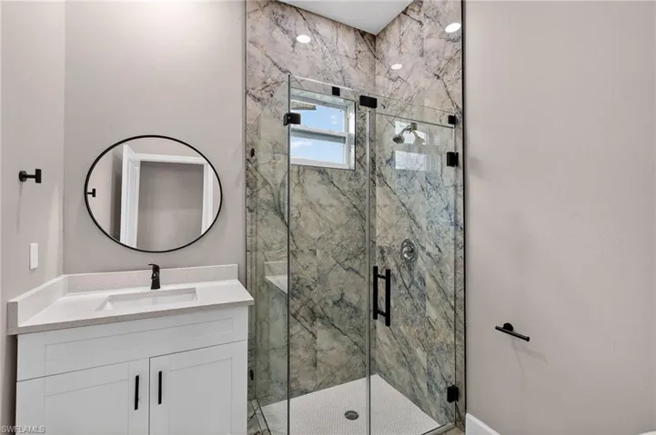 Full bathroom with vanity and a marble finish shower