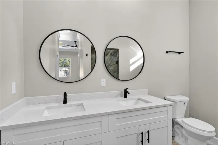 Bathroom featuring double vanity and a ceiling fan