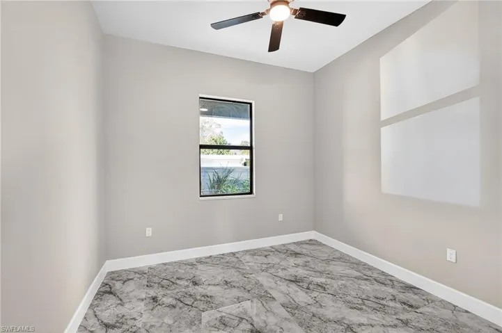 Empty room featuring marble finish flooring and ceiling fan