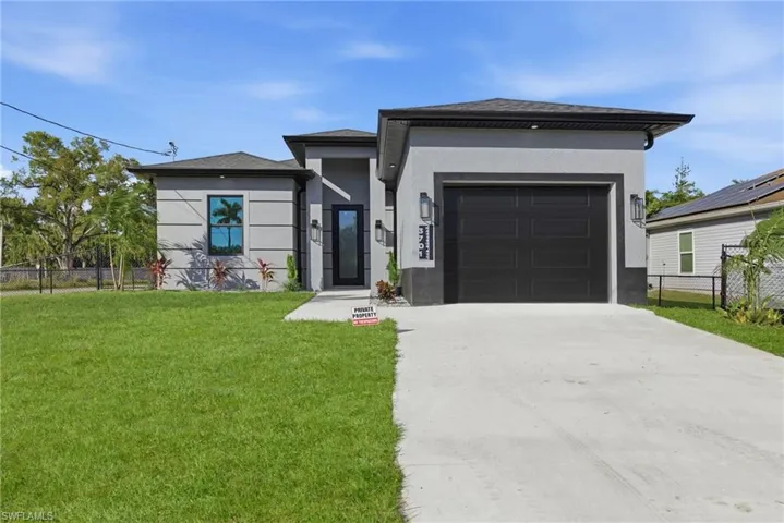 Prairie-style home with concrete driveway, stucco siding, and an attached garage