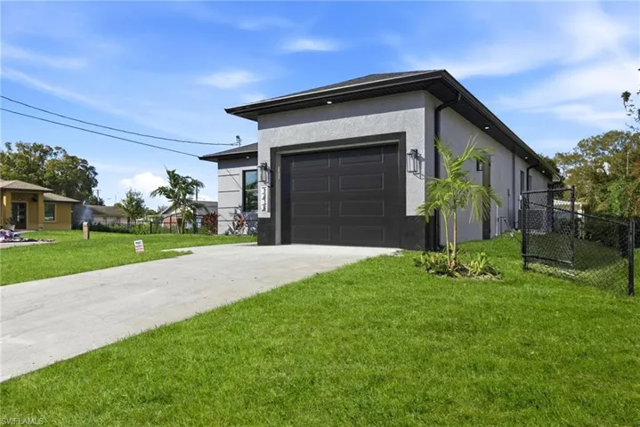 View of front of property with driveway, stucco siding, and an attached garage