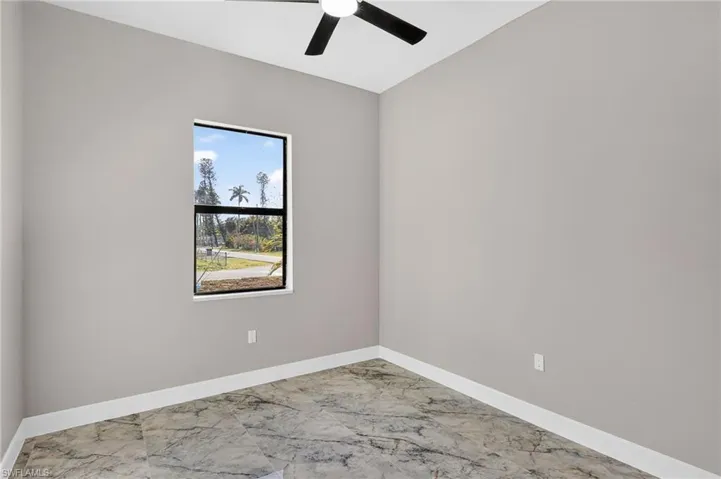 Unfurnished room with marble finish flooring and a ceiling fan