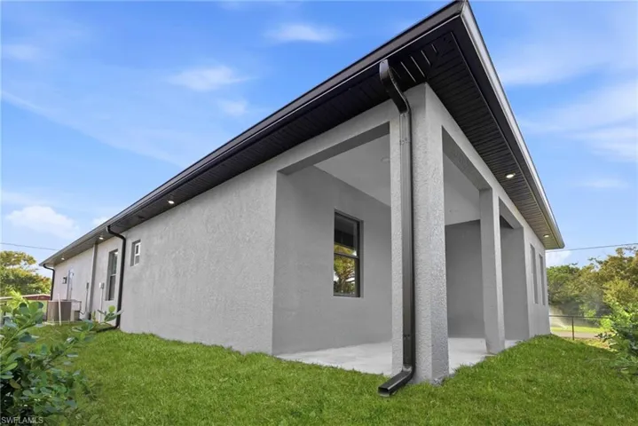 View of property exterior featuring stucco siding, a yard, and a patio area