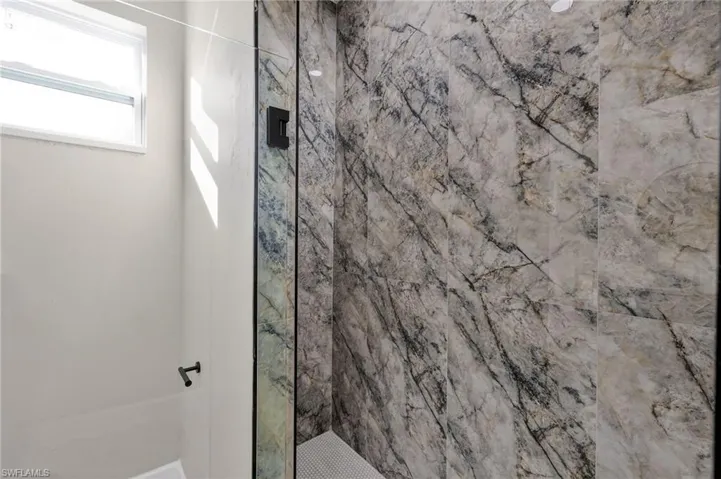 Full bath featuring a marble finish shower