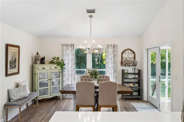 Dining space with plenty of natural light, visible vents, and wood finished floors