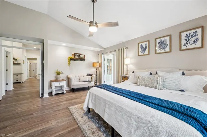 Bedroom with high vaulted ceiling, a ceiling fan, baseboards, and wood finished floors