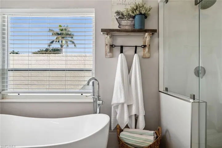 Bathroom featuring a healthy amount of sunlight, a stall shower, and a soaking tub