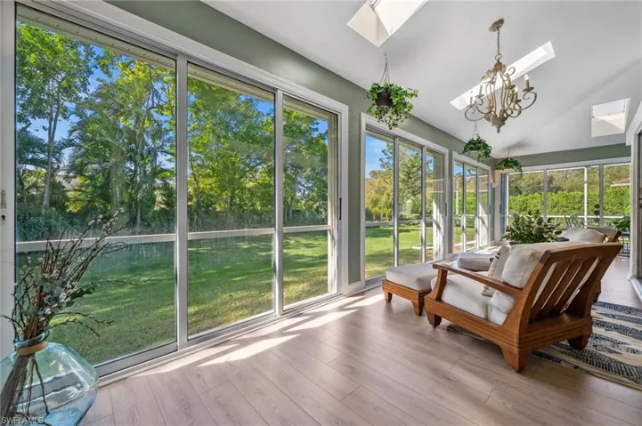 Sunroom / solarium featuring a chandelier and vaulted ceiling with skylight