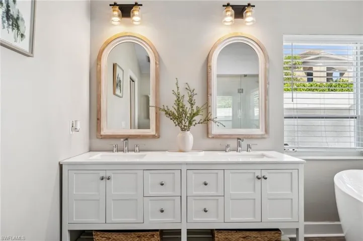 Full bathroom with a soaking tub, a sink, and double vanity