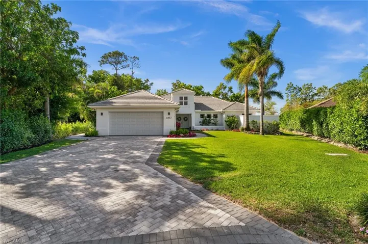 View of front of house featuring a garage, a tiled roof, decorative driveway, stucco siding, and a front yard