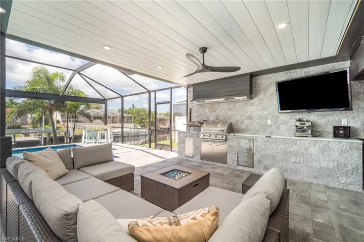 Tiled living room featuring wooden ceiling, ceiling fan, and a wall of windows