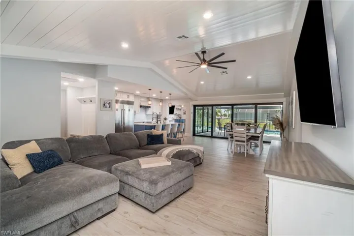 Living room shiplap volume ceiling, ceiling fan, tile plank flooring