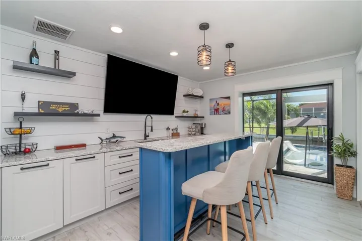 bar room has commercial ice maker, refrigerator and high top bar/seating.