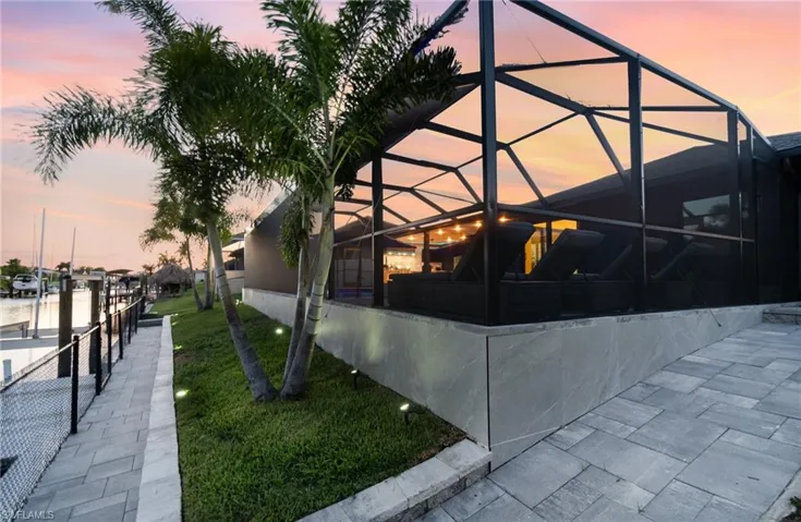 Property exterior at dusk featuring a lanai and a water view