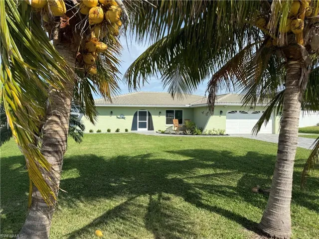 View of front facade with a garage and a front lawn
