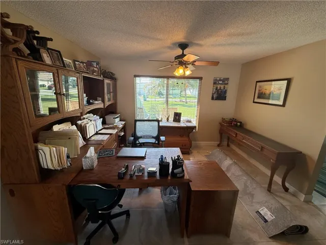 Office space with a textured ceiling and ceiling fan