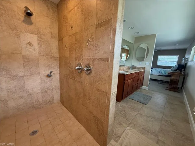 Full bathroom featuring ensuite bathroom, vanity, and a tile shower