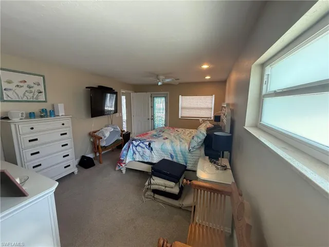 Bedroom with ceiling fan, carpet floors, and access to outside