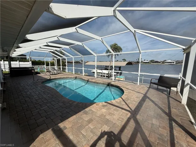 View of pool with a lanai, a patio, and a water view