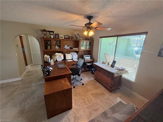 Home office with ceiling fan and a textured ceiling