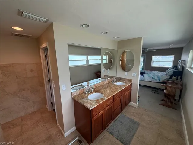Ensuite bathroom with double vanity, ceiling fan, recessed lighting, and tile patterned flooring