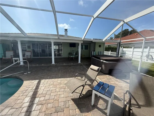 View of patio with a pool with hot tub and glass enclosure