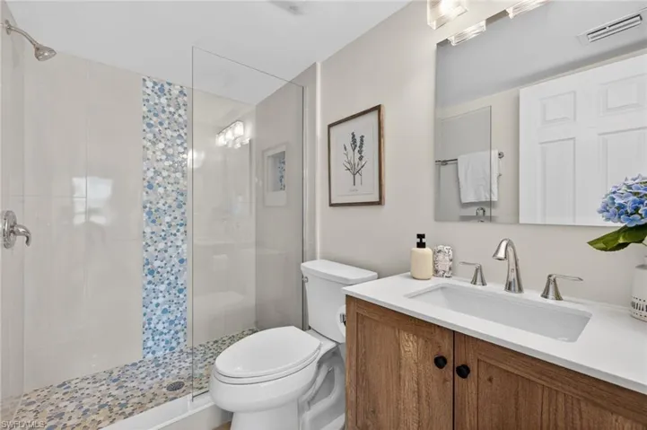 Master Bathroom with decorative tile, coastal vanity and upscale lighting
