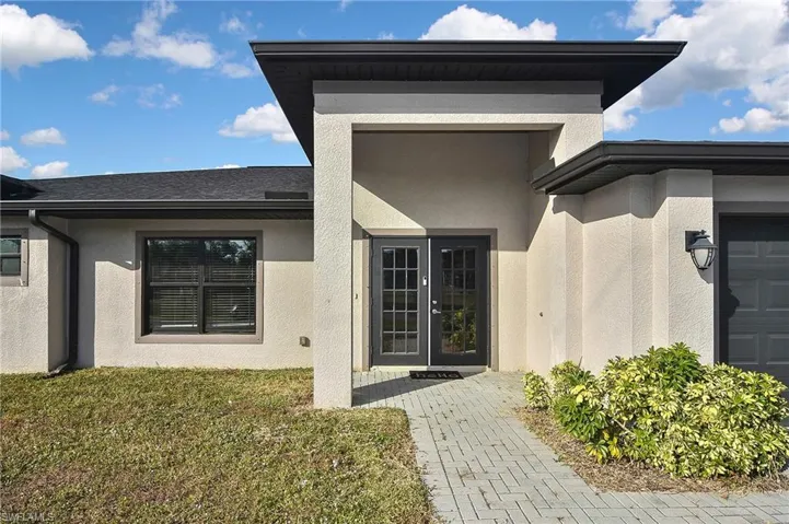 Doorway to property featuring a yard and french doors