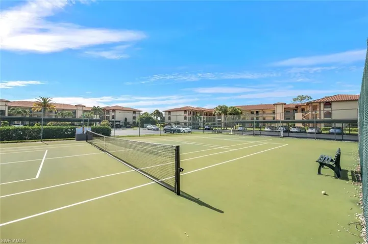View of tennis court featuring a residential view and community basketball court