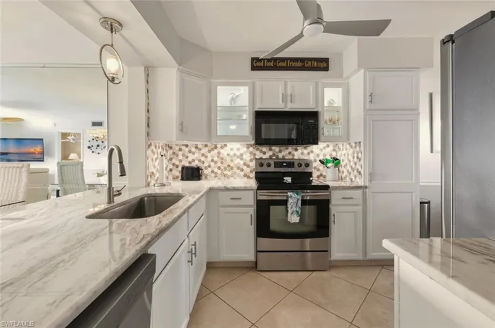 Kitchen featuring ceiling fan, stainless steel appliances, and white cabinets