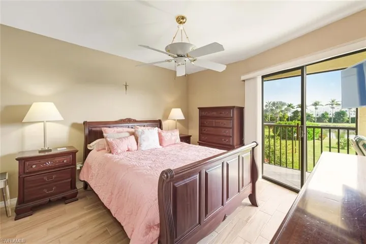 Bedroom featuring access to exterior, light wood-style floors, and a ceiling fan
