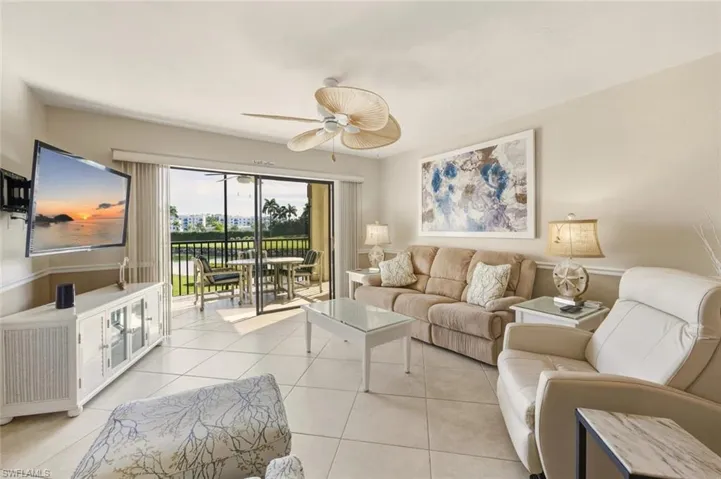 Living room featuring a ceiling fan and light tile patterned floors