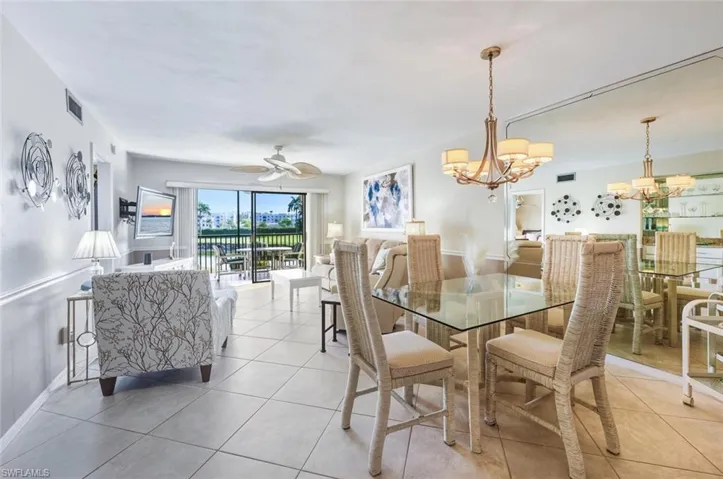 Dining room with ceiling fan, light tile patterned flooring, and a chandelier