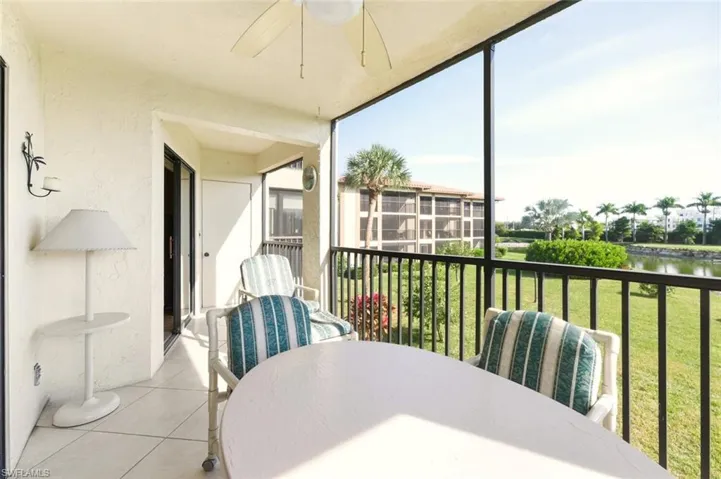 Sunroom featuring outdoor dining space, a ceiling fan, a balcony, and a water view