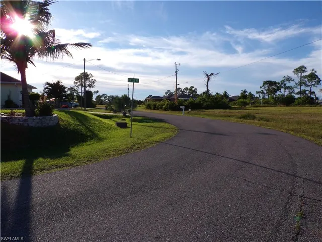 View of asphalt street featuring street lights