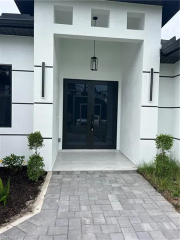 Doorway to property featuring french doors and stucco siding