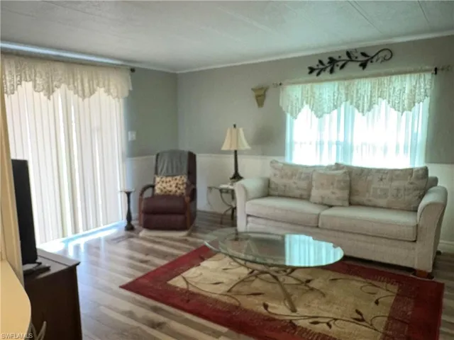 Living room featuring crown molding and wood-type flooring