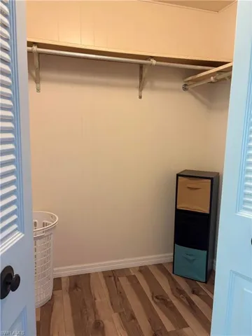 Spacious closet with dark hardwood / wood-style floors