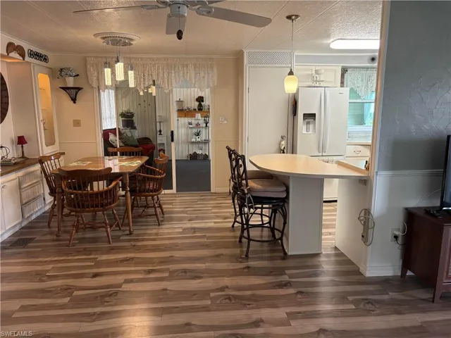 Dining space featuring dark hardwood / wood-style flooring, crown molding, and ceiling fan