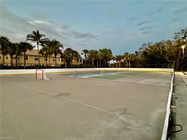Multi-sport court featuring a concrete surface, perimeter fencing, and integrated lighting