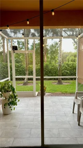 Screened patio featuring string lighting, wood-finish ceiling, and light-toned rectangular floor tiles