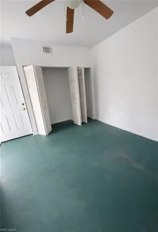 Unfurnished bedroom featuring multiple closets and a ceiling fan
