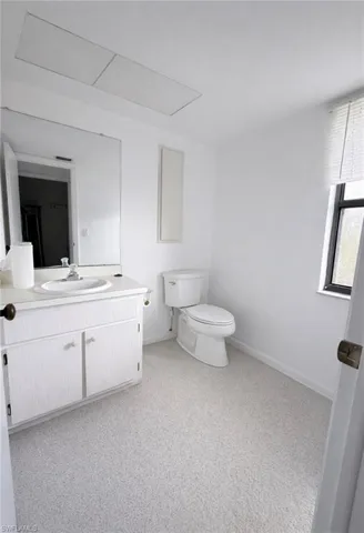 Half bathroom with vanity and light carpet