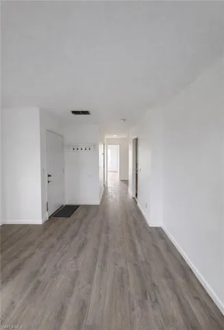 Unfurnished room with dark wood-type flooring and baseboards