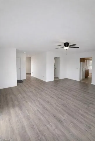 Unfurnished living room featuring light wood-type flooring and ceiling fan