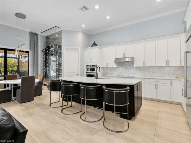 Eat-In Kitchen With Custom Tile & Glass Wine Wall, Large Island, Quartz Counters, Marble Backsplash, Walk-in Pantry, KitchenAid Stainless Steel Appliances, and Built-In Refrigerator