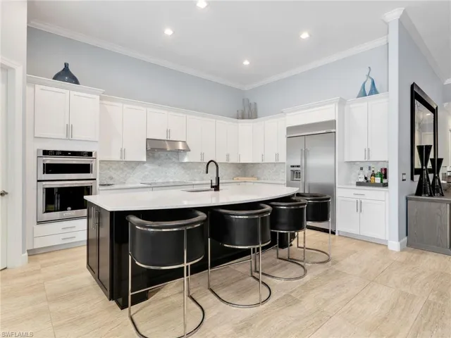 Kitchen With Large Island, Quartz Counters, Marble Backsplash, KitchenAid Stainless Steel Appliances and Built-In Refrigerator