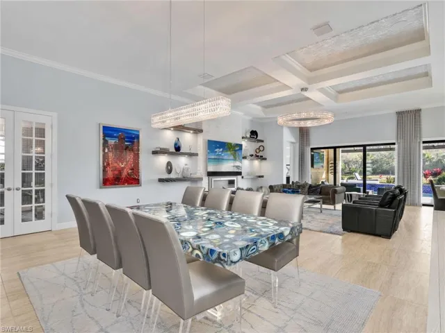 Great Room With Coffered Ceiling With Custom Wall Coverings, Dining Area, Living Area, Stone Feature Wall With Fireplace, WHOLE-HOME SONOS AUDIO With In-Ceiling Speakers & Soundbars & Wi-Fi Extenders, Custom Shelving with Integrated Lighting, Restoration Hardware Chandeliers, Custom Draperies, and Sliders to Lanai/Pool Area