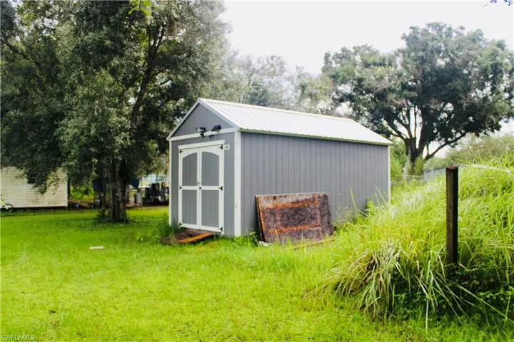 View of outbuilding with a lawn